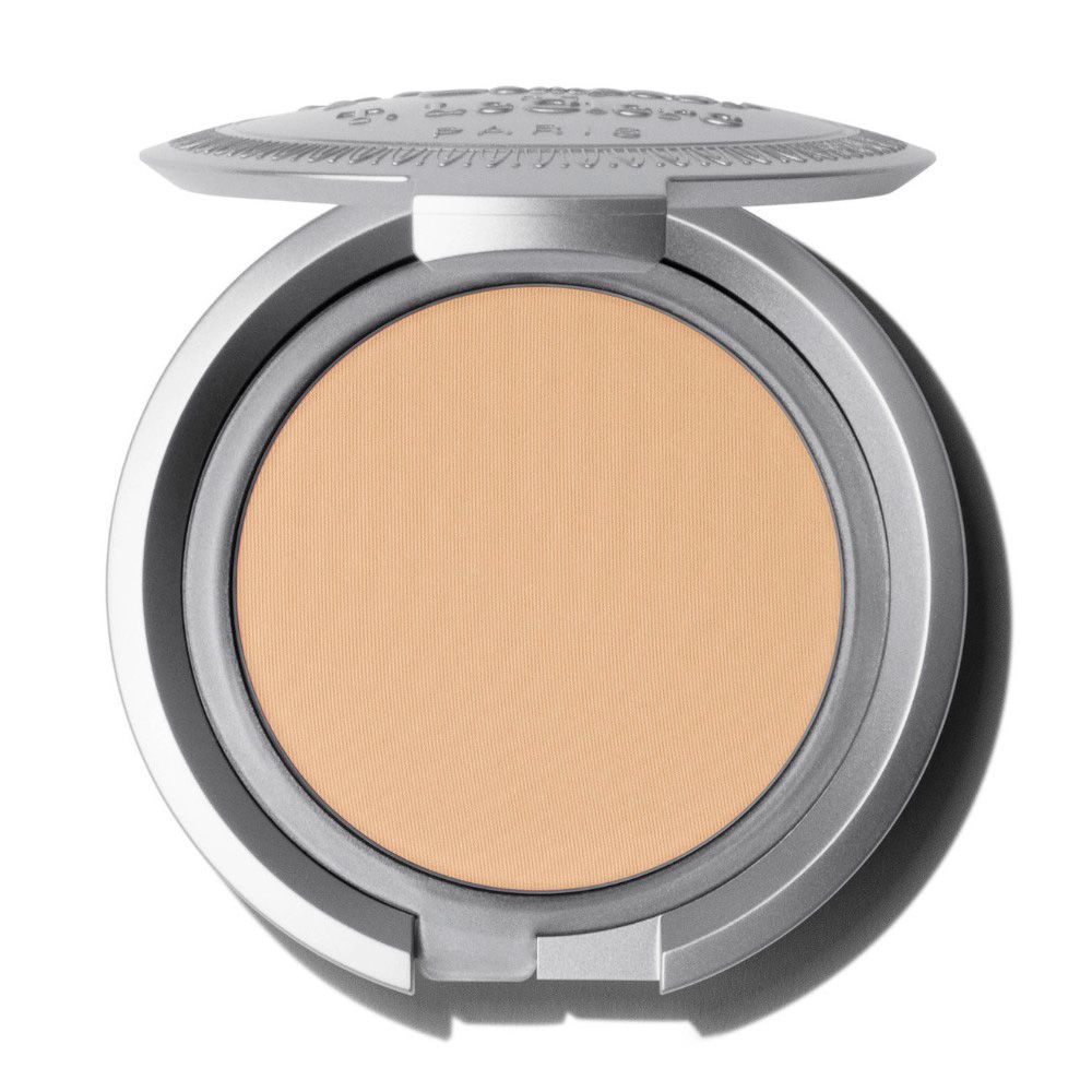 Poudre compacte claire dans un boîtier argenté. Couvercle ouvert, produit visible.