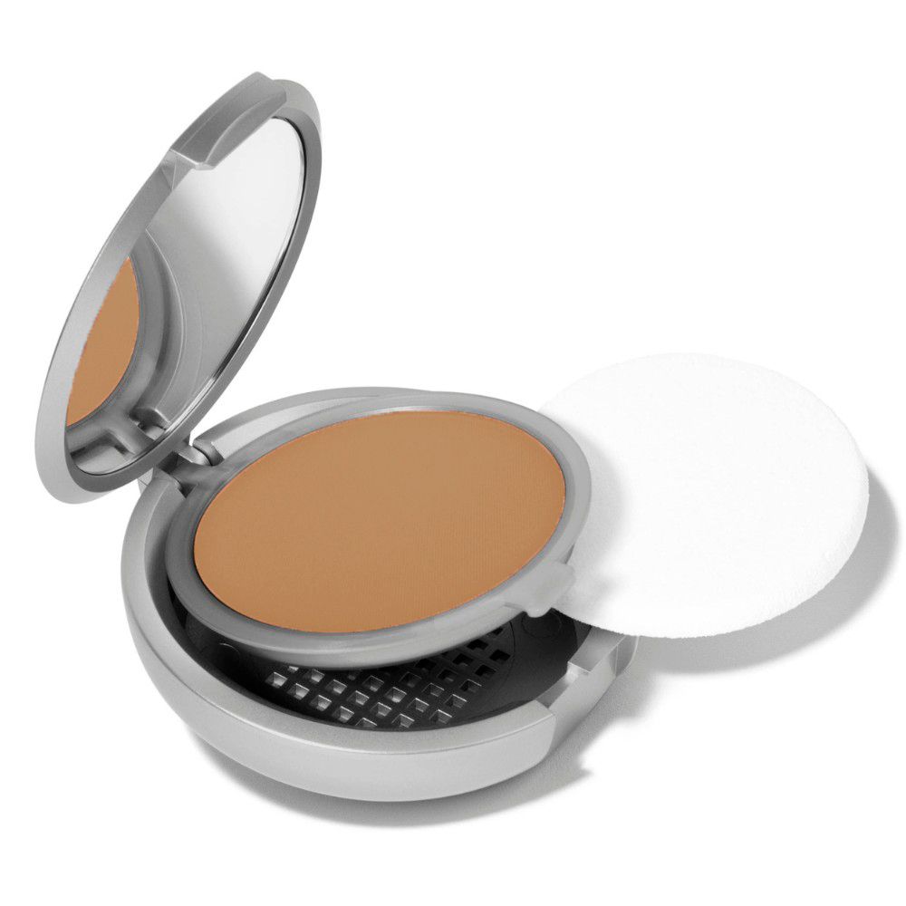 Poudre compacte ronde argentée avec poudre et miroir. Couvercle ouvert.