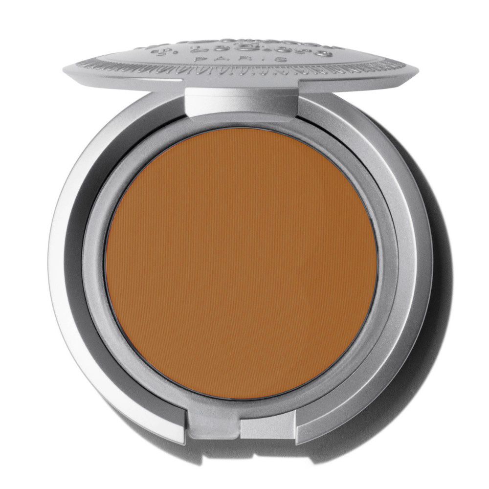Boîtier compact rond argenté, ouvert. Poudre brune. Couvercle ouvert.