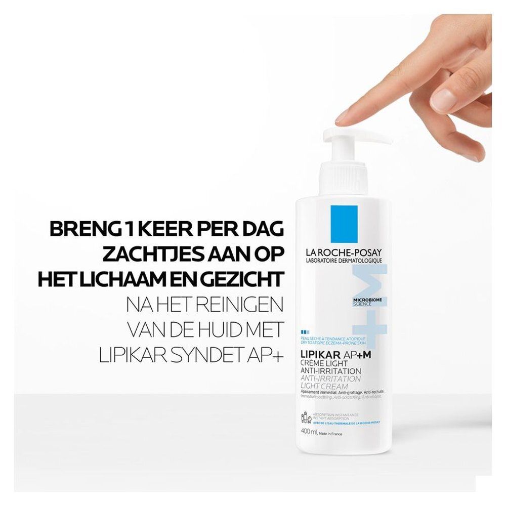 Personne touchant un flacon. La Roche-Posay, Lipikar AP+M Crème Light. Texte : Appliquer une fois par jour.