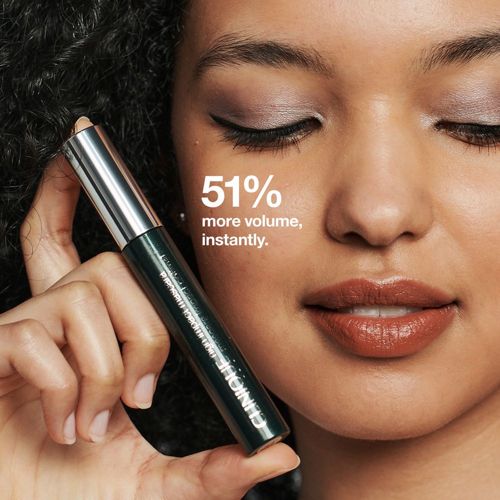 Frau hält Mascara. Text: 51% mehr Volumen, sofort. Mascara-Tube in der Hand.