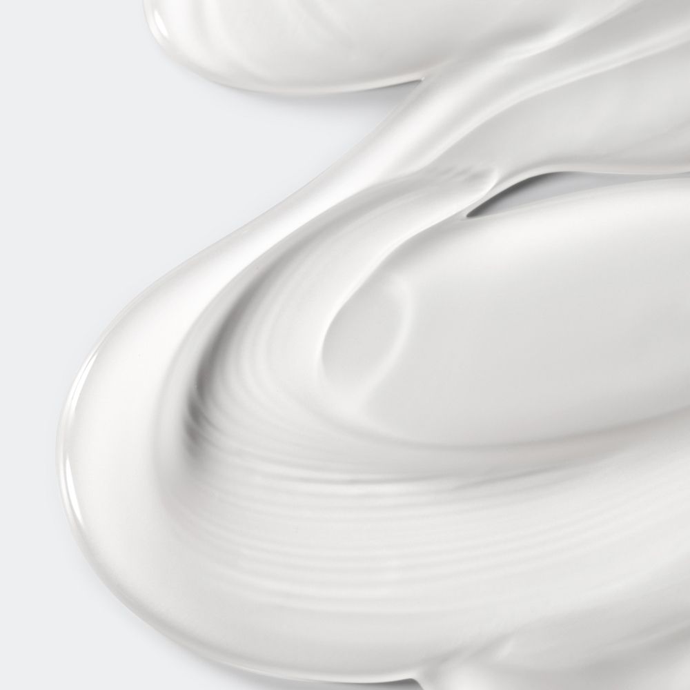 Nahaufnahme von weißer Creme. Die Creme ist gewellt und hat eine glatte Textur.