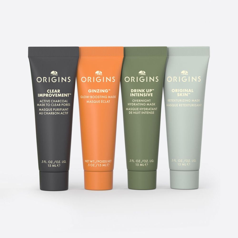 Vier Tuben Gesichtsmaske. Schwarz, Orange, Grün und Hellgrün. Aufdrucke: Origins, Produktnamen und Inhaltsstoffe.