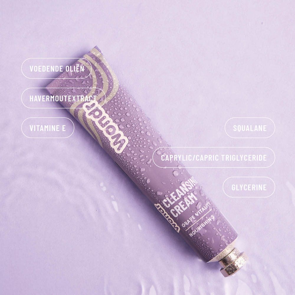 Paarse tube met ingrediëntlabels: "Voedende oliën", "Havermoutextract", "Vitamine E", "Squalane", etc. Op paarse achtergrond.