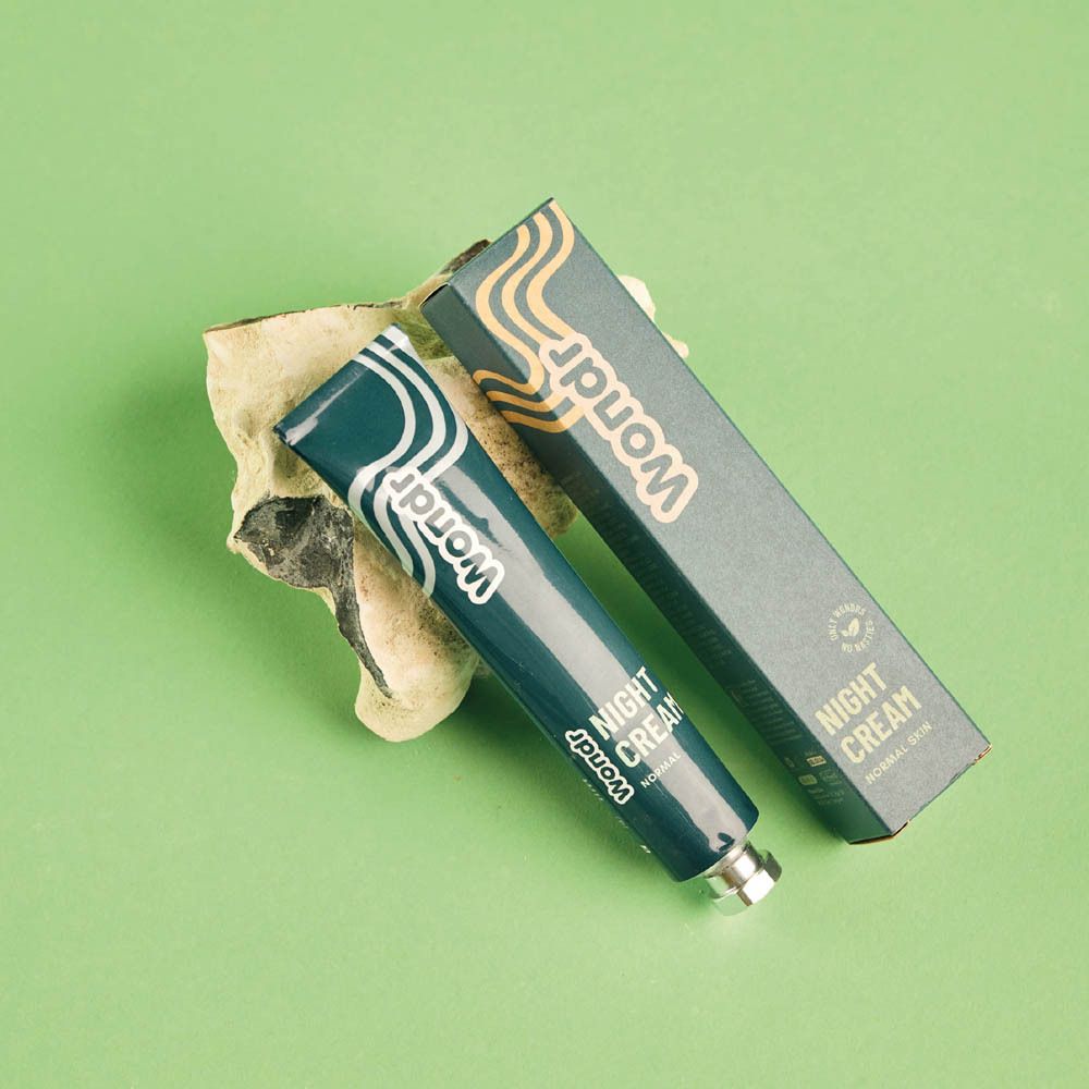 Tube et crème sur fond vert.