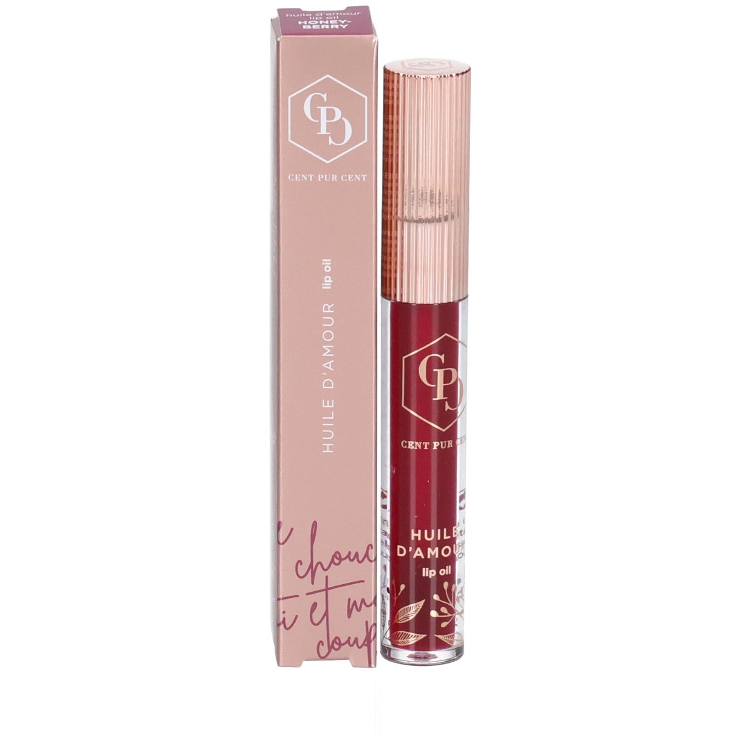 Lippenöl und Verpackung. Die Verpackung ist rosa und zeigt den Produktnamen und das Logo. Das Lippenöl ist in einer transparenten Flasche.