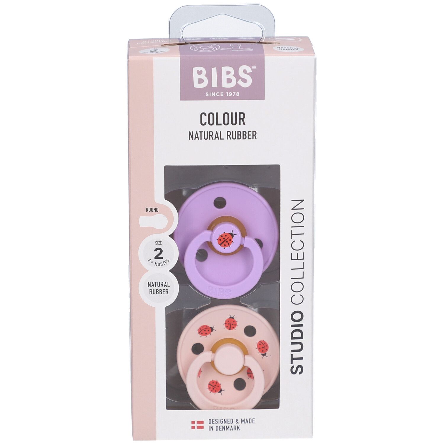 Verpackung mit zwei Schnullern. Lila und rosa Sauger mit Marienkäfer-Motiv. Naturgummi. BIBS-Marke.