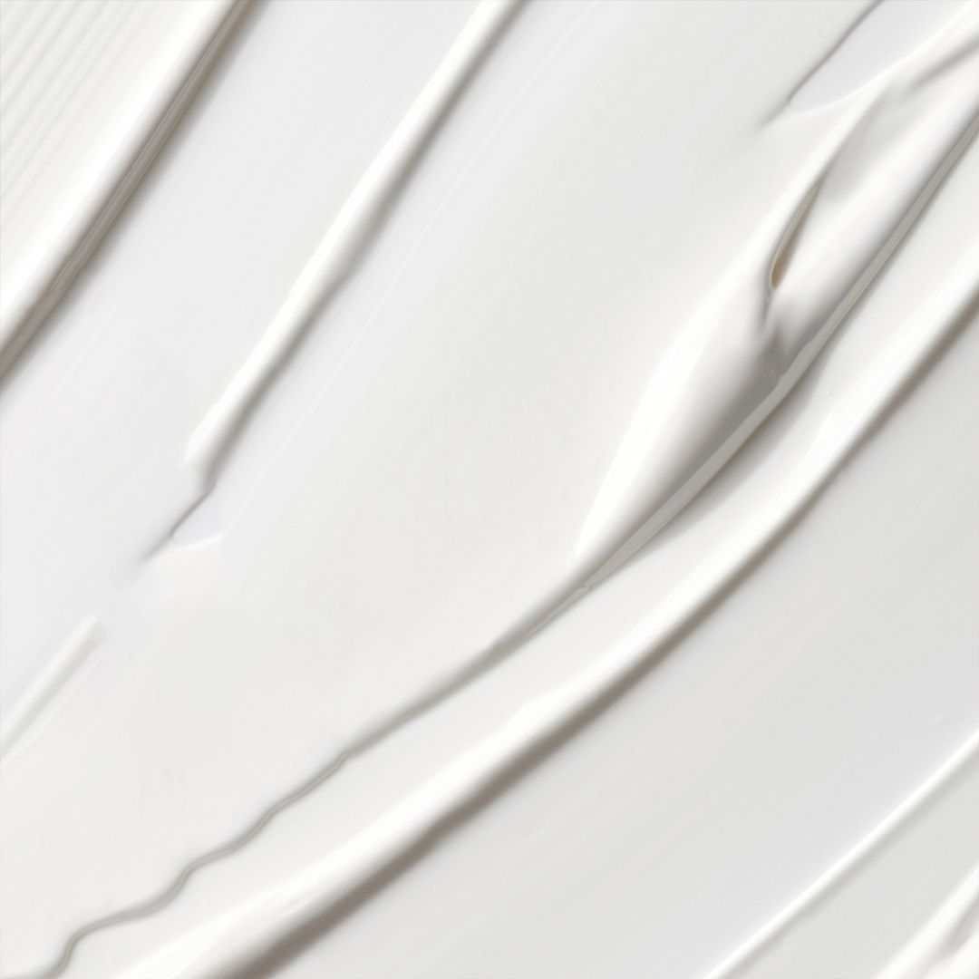 Nahaufnahme von weißer Creme. Die Creme ist in wellenförmigen Linien aufgetragen.