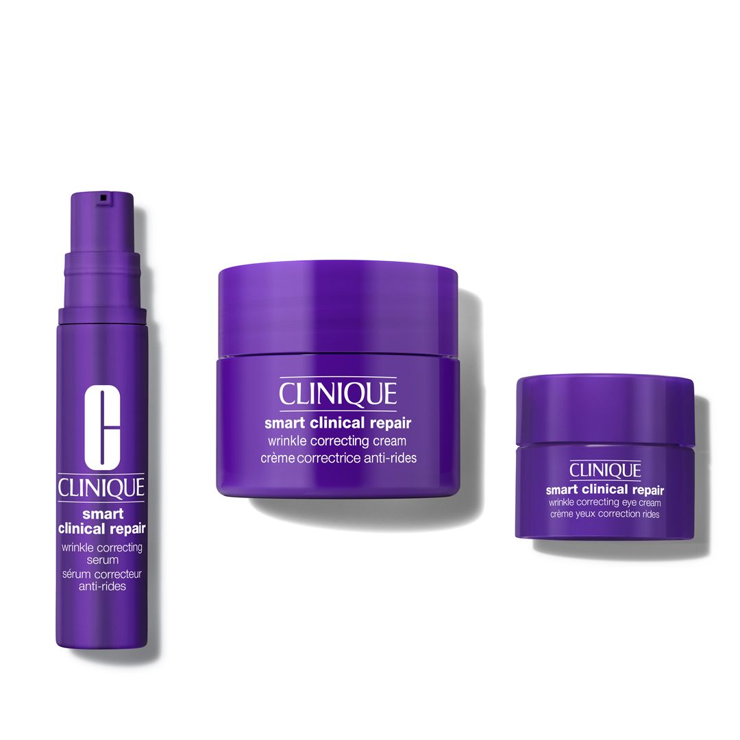 Drei Clinique Produkte: Serum, Anti-Falten-Creme und Augencreme. Lila Tiegel und Flasche. Aufschrift: Clinique Smart Clinical Repair.