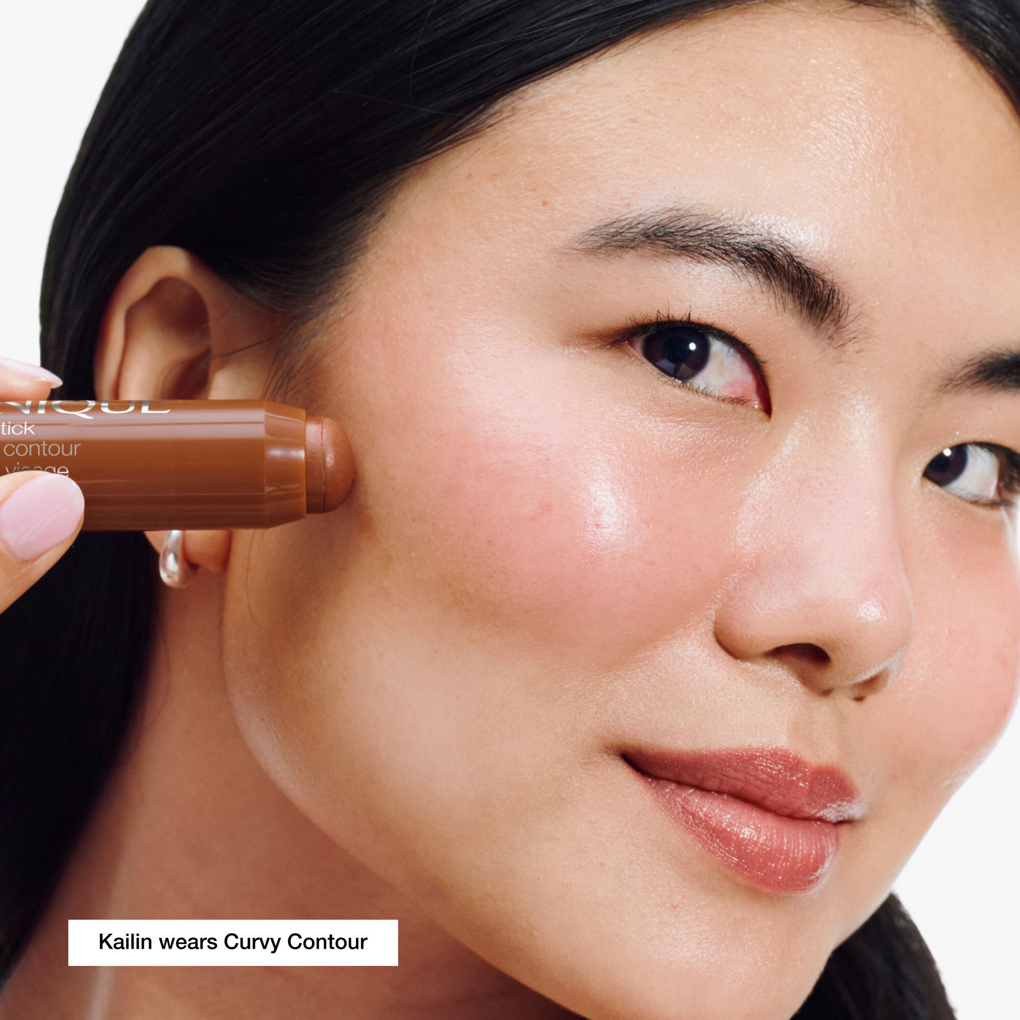 Frau trägt Clinique Chubby Stick™ Contour sculptant 01 Curvy Contour. Braune Farbe auf der Haut.