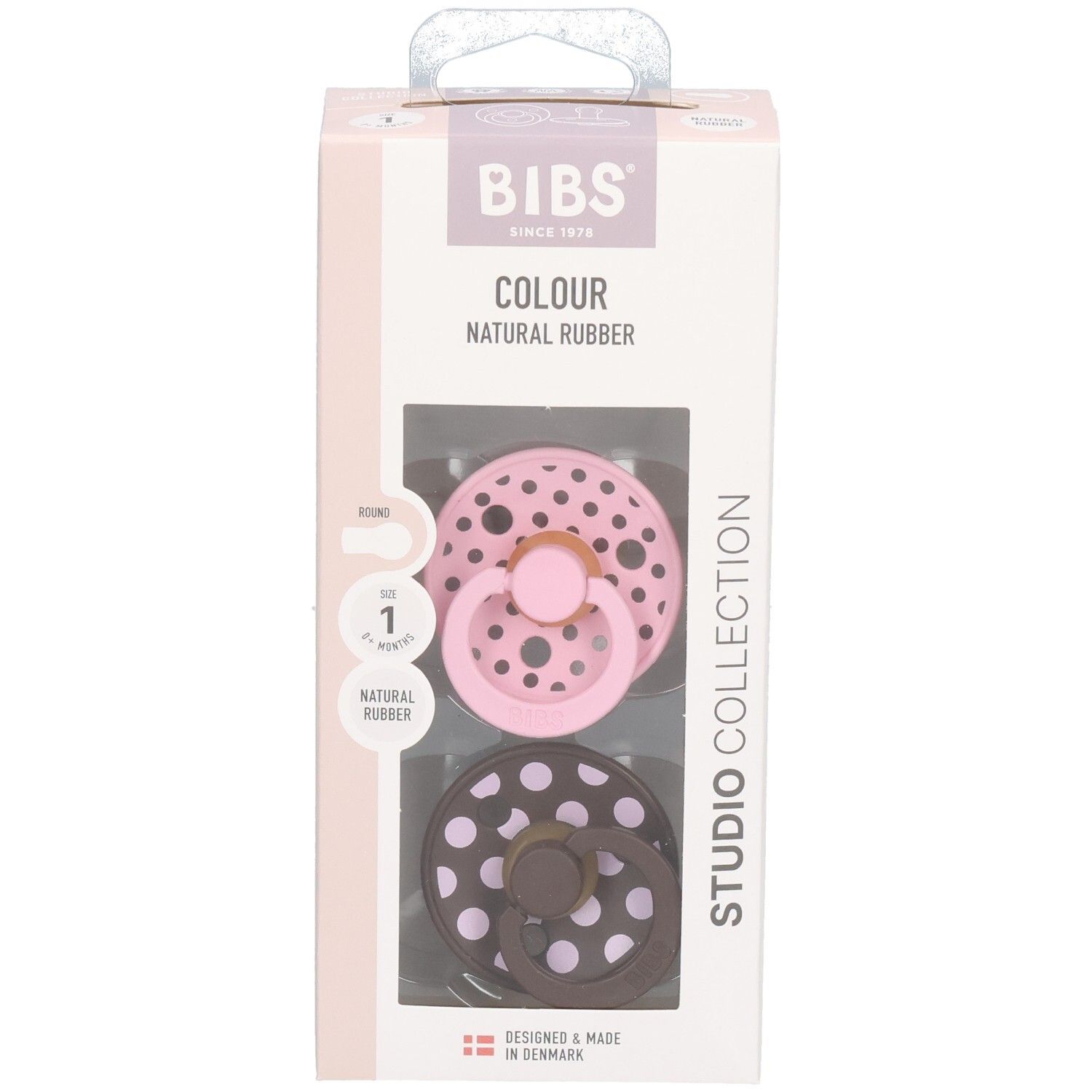 Verpackung mit zwei Schnullern. Rosa und braun mit weißen Punkten. Marke: BIBS. Sichtfenster.