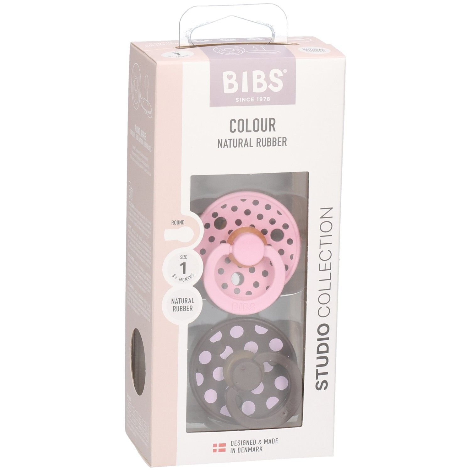 Verpackung mit zwei Schnullern. Rosa und braun mit weißen Punkten. Marke: BIBS. Sichtfenster.