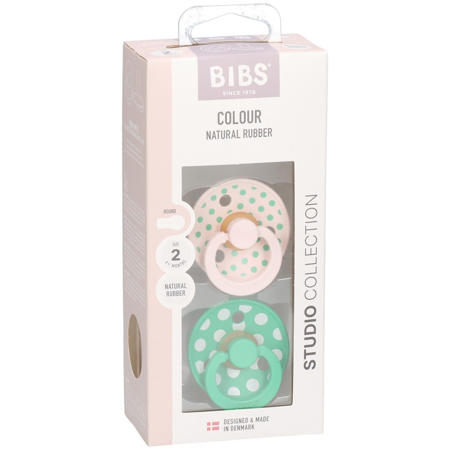 Verpackung mit zwei Schnullern. Rosa und grüne Schnuller mit weißen Punkten. Marke: BIBS. Naturgummi.