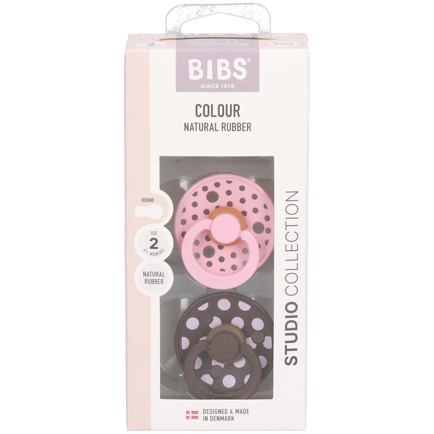 Verpackung mit zwei Schnullern. Rosa und braun mit weißen Punkten. Marke: BIBS. Text: Colour, Natural Rubber, Studio Collection.