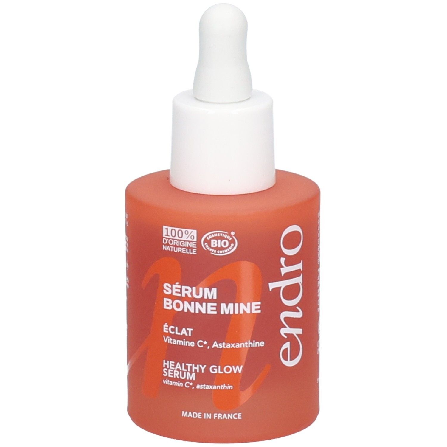 Endro Sérum Bonne Mine Flasche mit Pipette. Orangefarbenes Glas mit weißem Verschluss und Schriftzug.