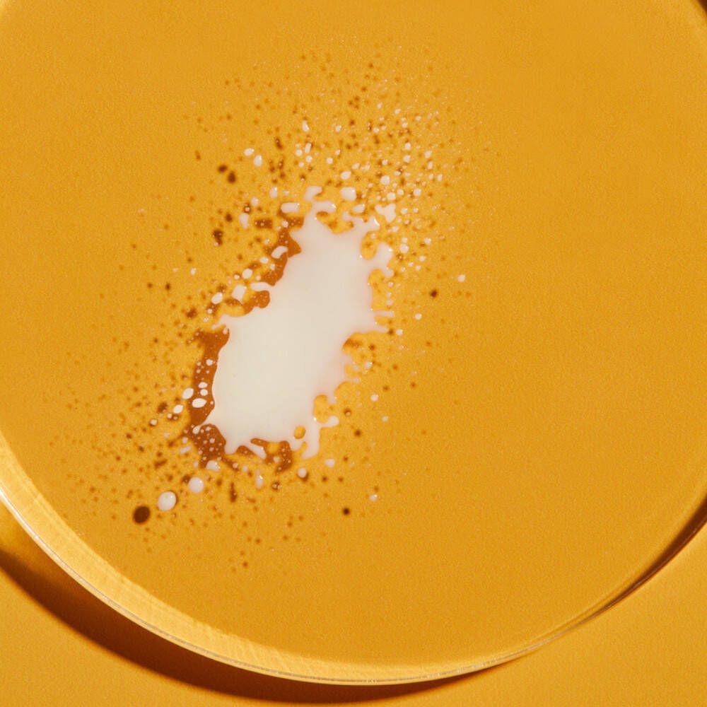Fond jaune avec liquide blanc. Quelques points bruns et noirs.