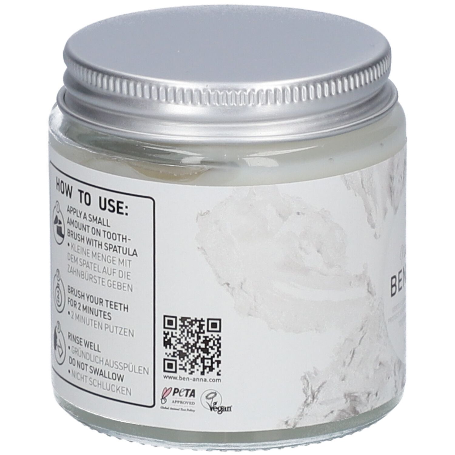 Rückseite des Zahnpasta-Glasgefäßes. Enthält Anweisungen zur Anwendung, QR-Code, PETA-Logo und Vegan-Siegel.