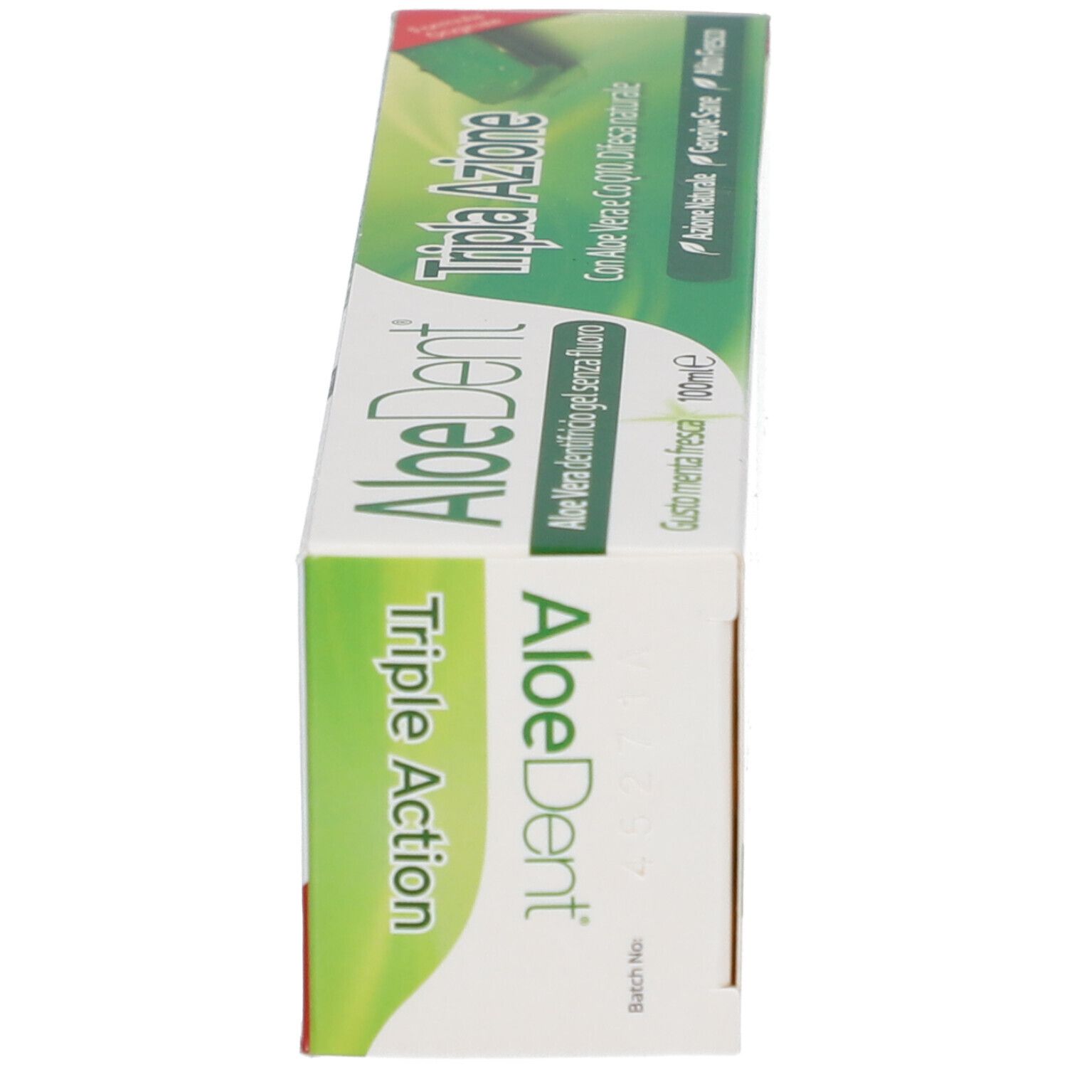 Boîte de dentifrice, en biais. Texte: AloeDent Triple Action, Aloe Vera, Cool Minty Freshness.