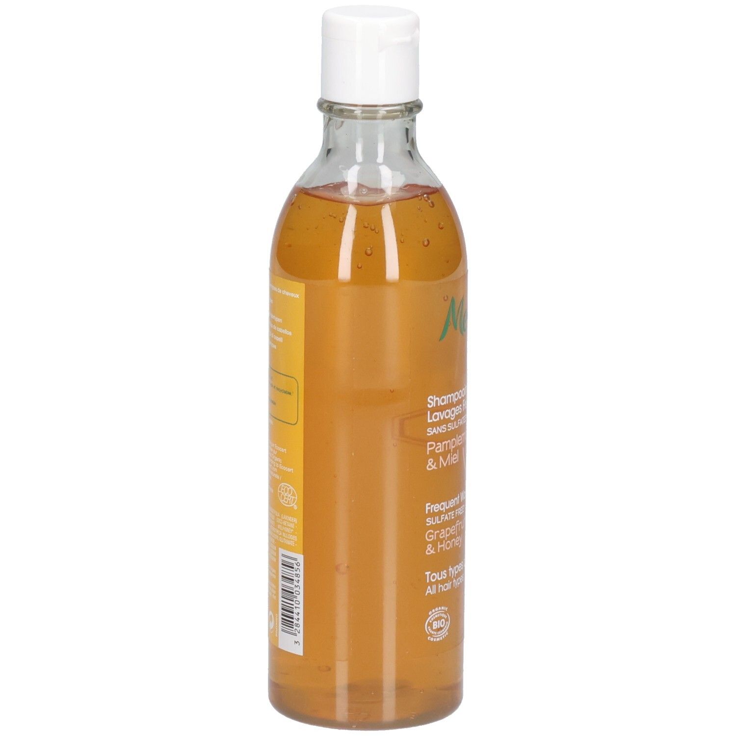 Eine Flasche Shampoo mit weißem Klappdeckel. Das Shampoo ist bernsteinfarben.