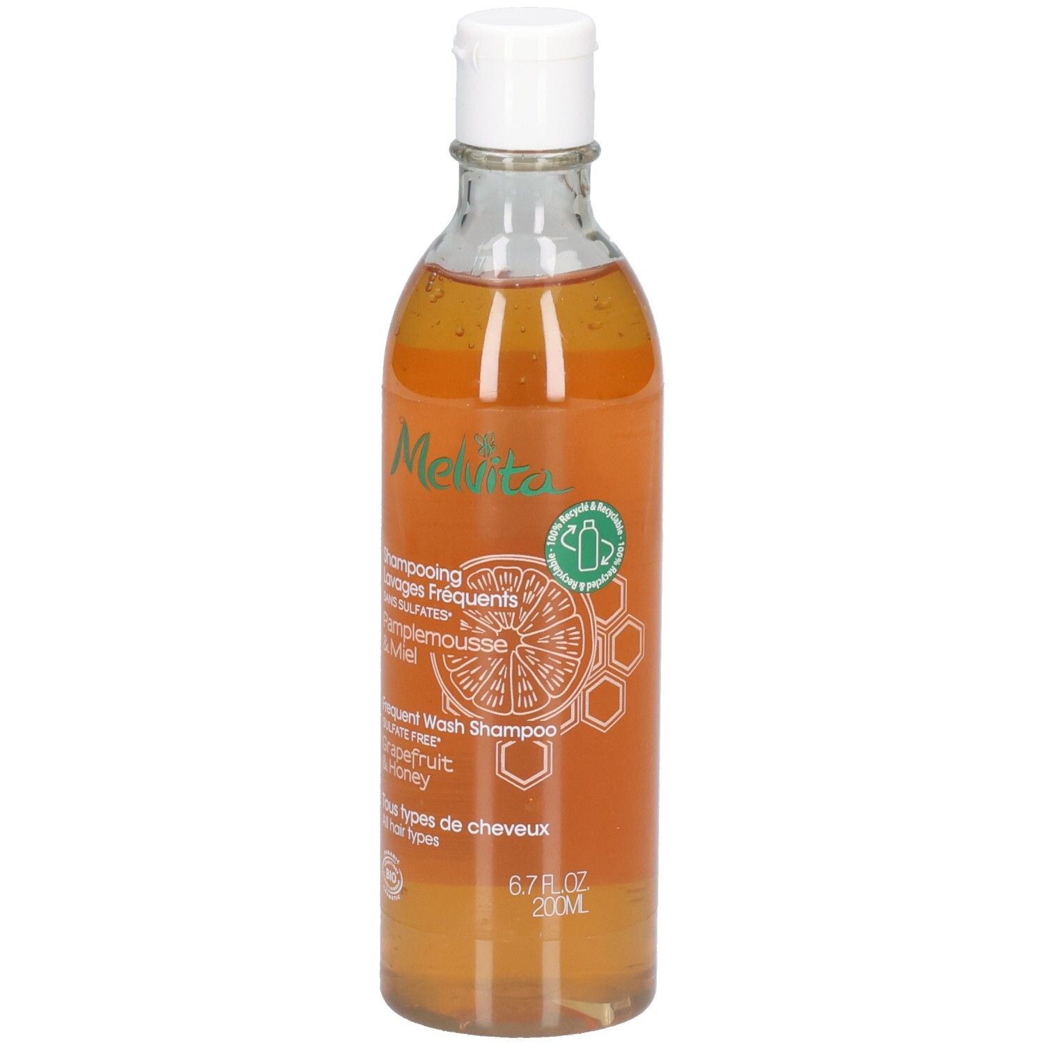 Melvita Shampoo Flasche mit weißem Verschluss. Enthält 200ml. Orangefarbene Flüssigkeit mit Grapefruit- und Honig-Aufdruck.