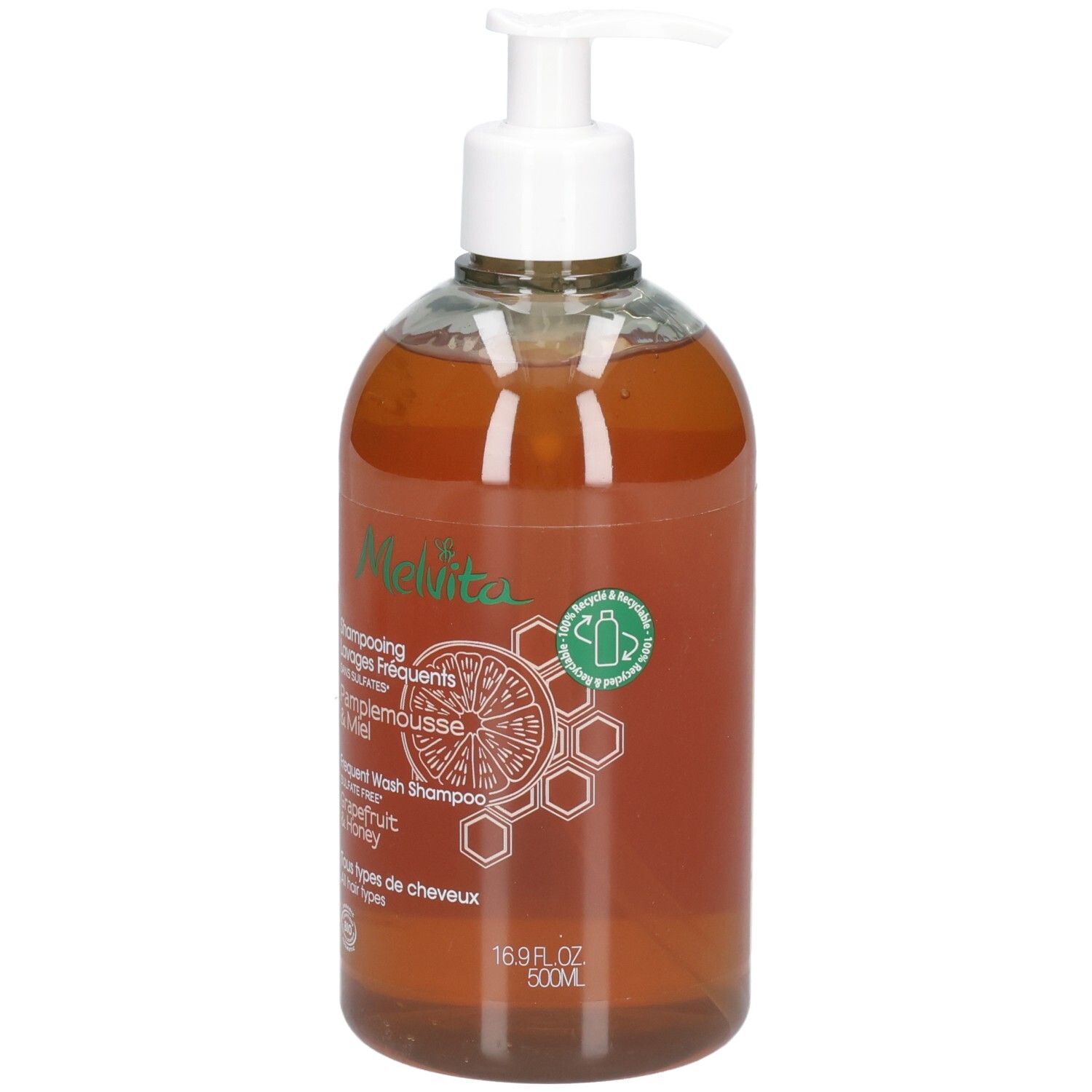 Klare Flasche mit weißem Pumpspender, gefüllt mit bernsteinfarbener Flüssigkeit. Etikett mit "Melvita"-Logo, Grapefruit- und Wabenmotiv.