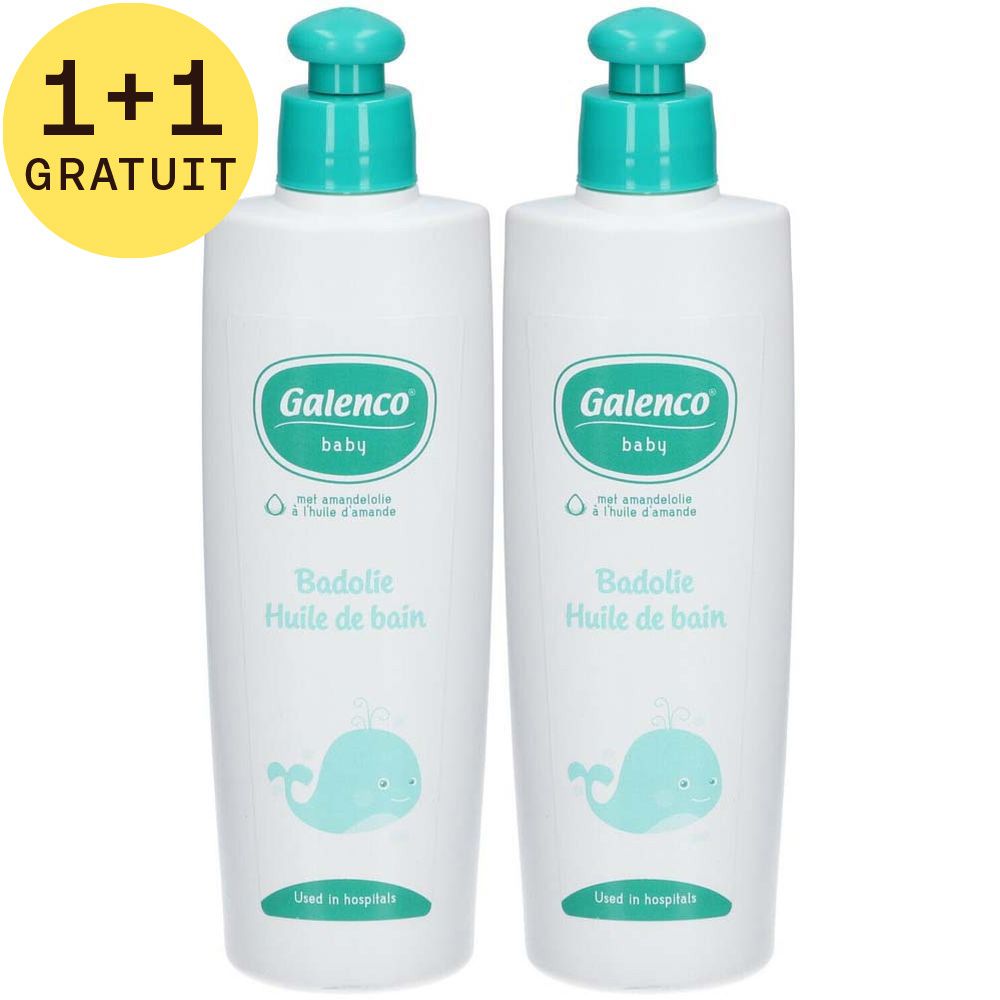 Deux flacons blancs Galenco Baby Huile de bain avec bouchon bleu et baleine. Texte: Badolie Huile de bain. Sticker: 1+1 GRATUIT.
