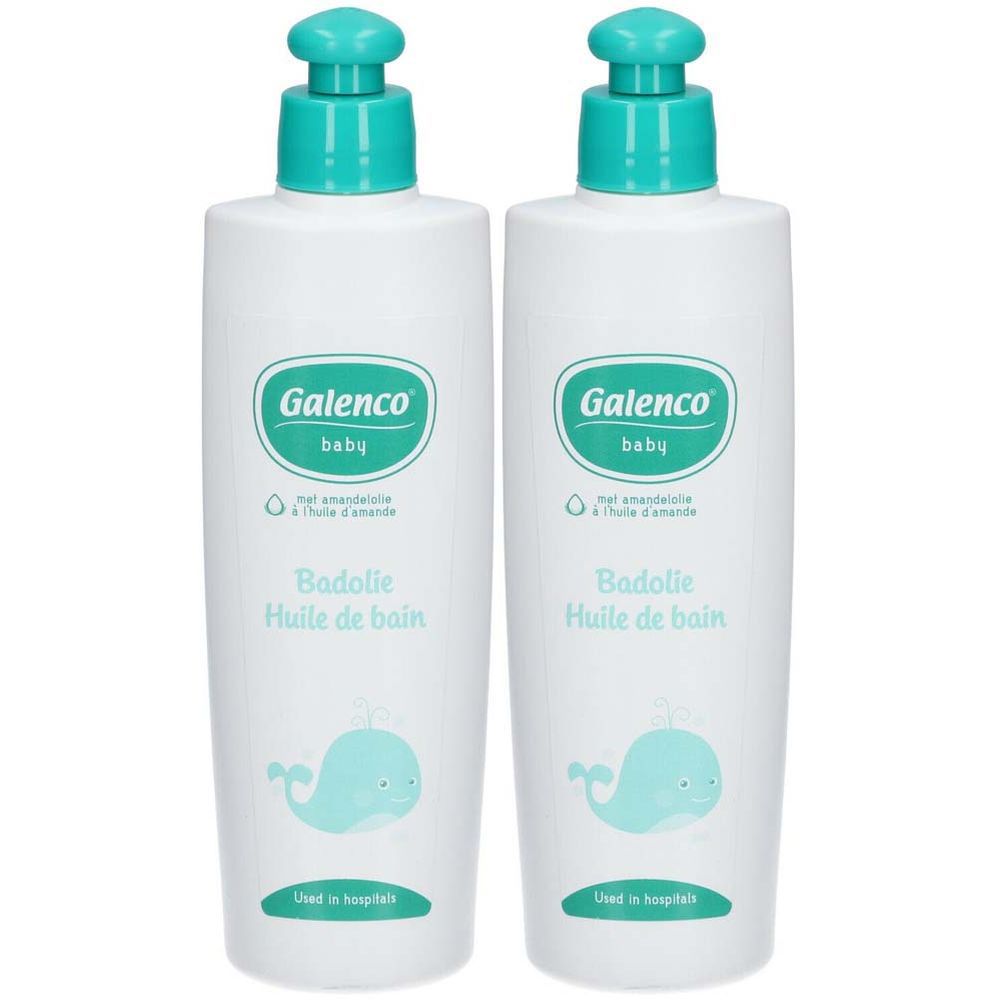 Deux flacons blancs Galenco Baby Huile de bain avec bouchon bleu et baleine. Texte: Badolie Huile de bain. Sticker: 1+1 GRATUIT.