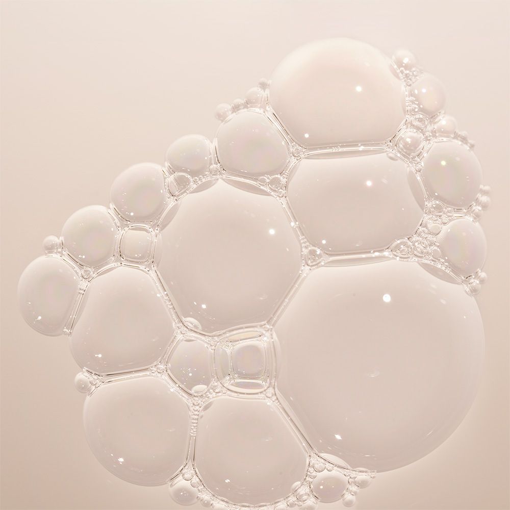 Bulles de liquide. Couleur claire, crémeuse. Gros plan.