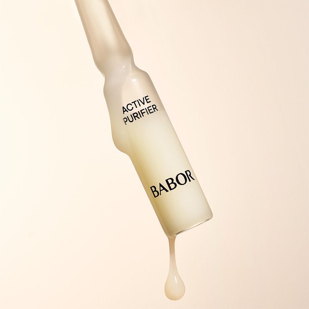 Ampul met gelige vloeistof. Vloeistof druppelt uit de ampul. Opschrift Active Purifier en Babor.