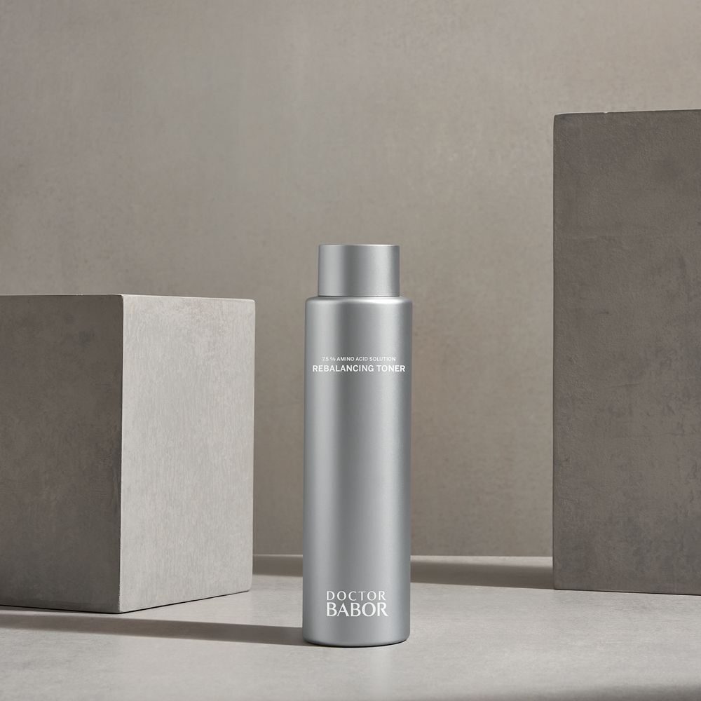 Flacon argenté avec bouchon à vis. Inscription : 75% Amino Acid Solution Rebalancing Toner. Marque : Doctor BABOR. Devant des blocs.