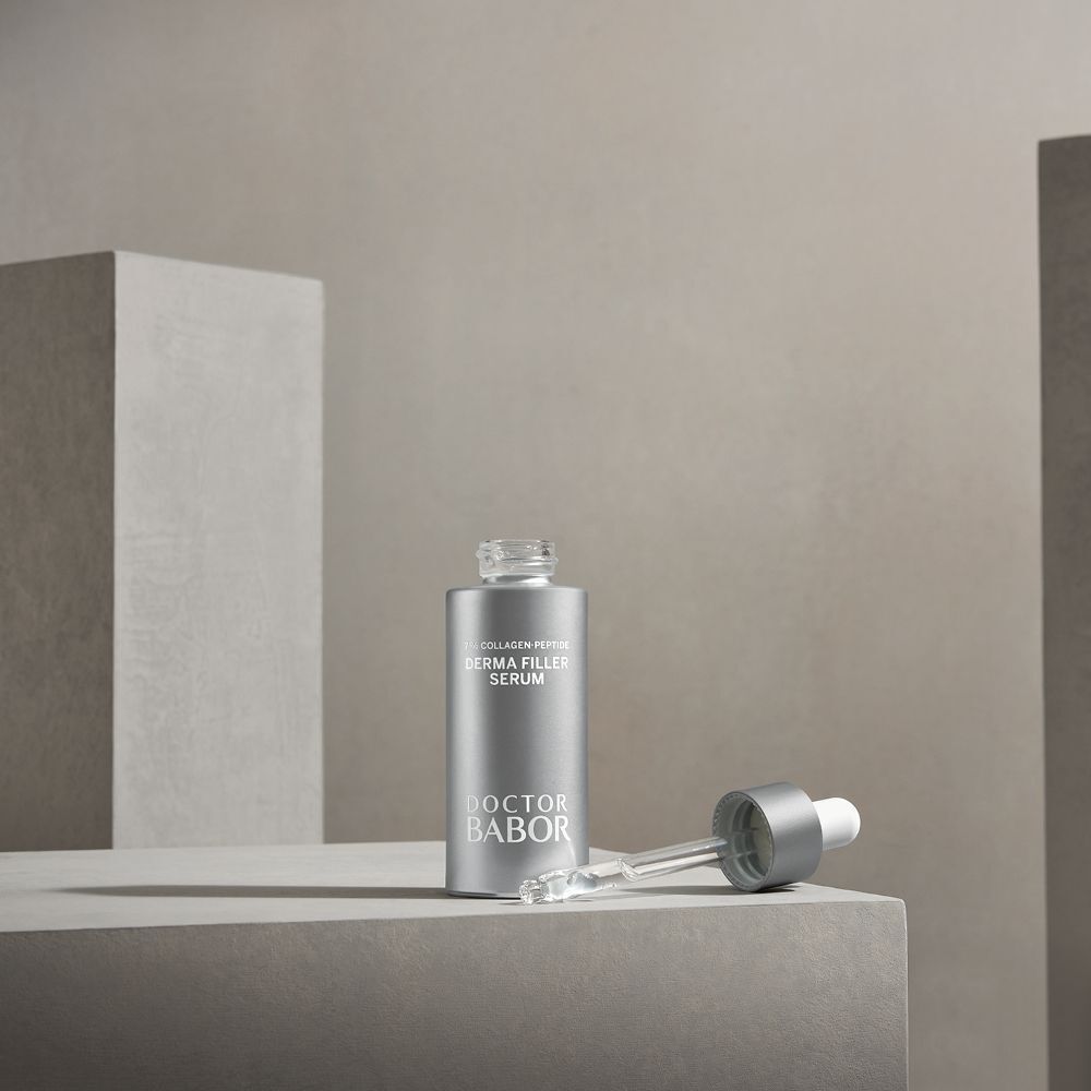 Flacon argenté avec compte-gouttes blanc et compte-gouttes à côté. Inscription : Derma Filler Serum, Doctor BABOR.