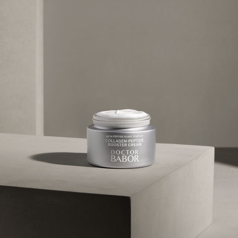 Pot ouvert avec crème sur une surface. Inscription : Collagen-Peptide Booster Cream, Doctor BABOR.