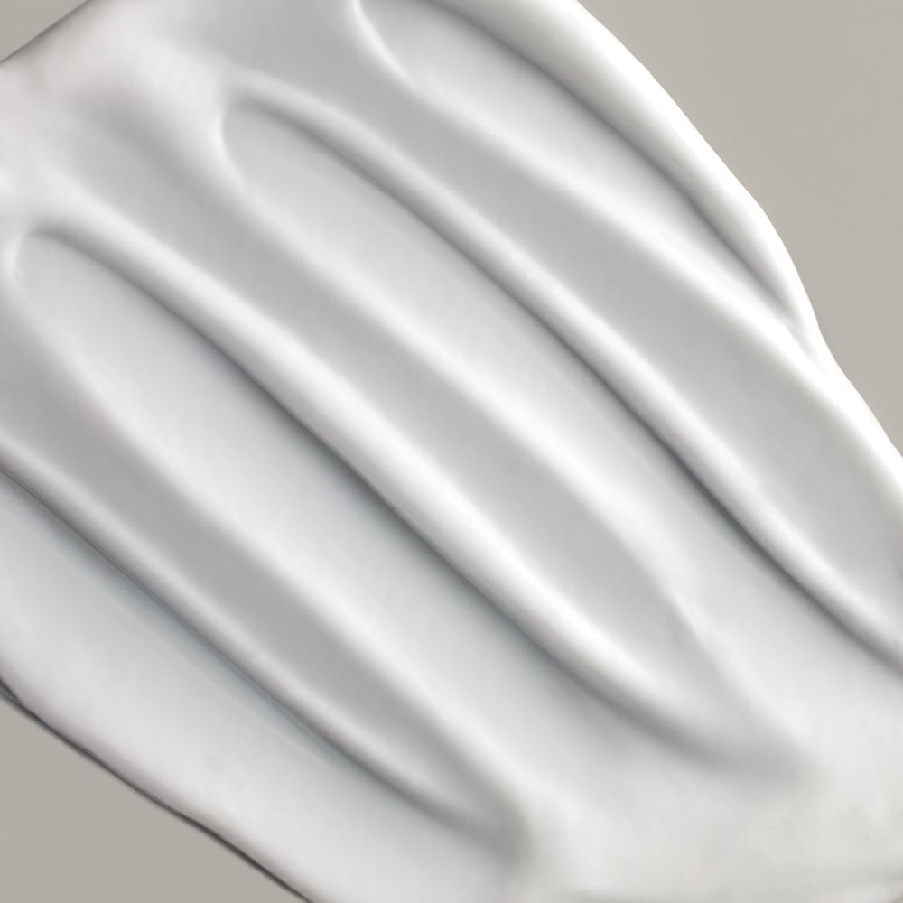 Gros plan sur une crème blanche. Texture avec des lignes ondulées.