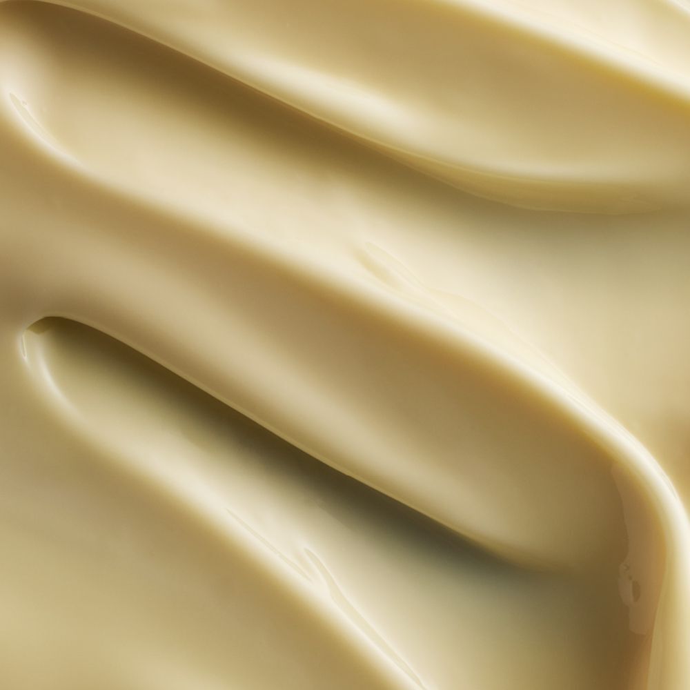 Gros plan sur une crème crémeuse, jaunâtre. Texture ondulée.