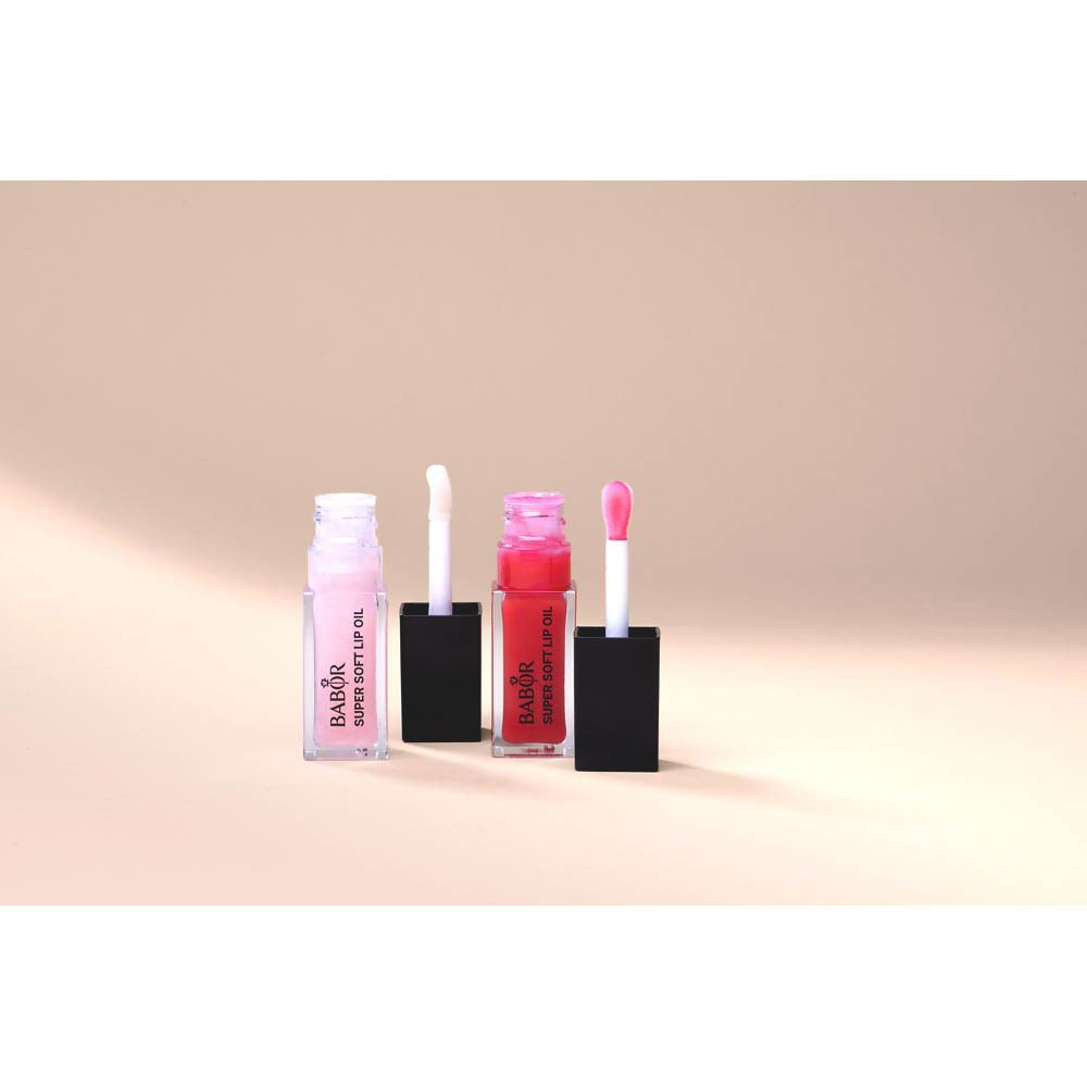 Drei Lip Oil Flaschen mit Applikatoren. Zwei sind rosa, eine rot. Schwarze Deckel. Aufschrift: Babor Super Soft Lip Oil.