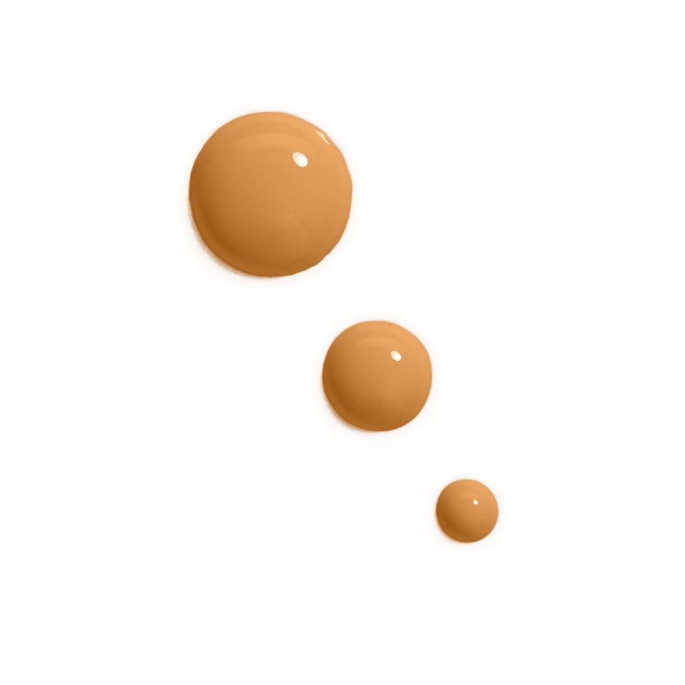 Drei Tropfen Foundation in verschiedenen Brauntönen auf weißem Hintergrund.