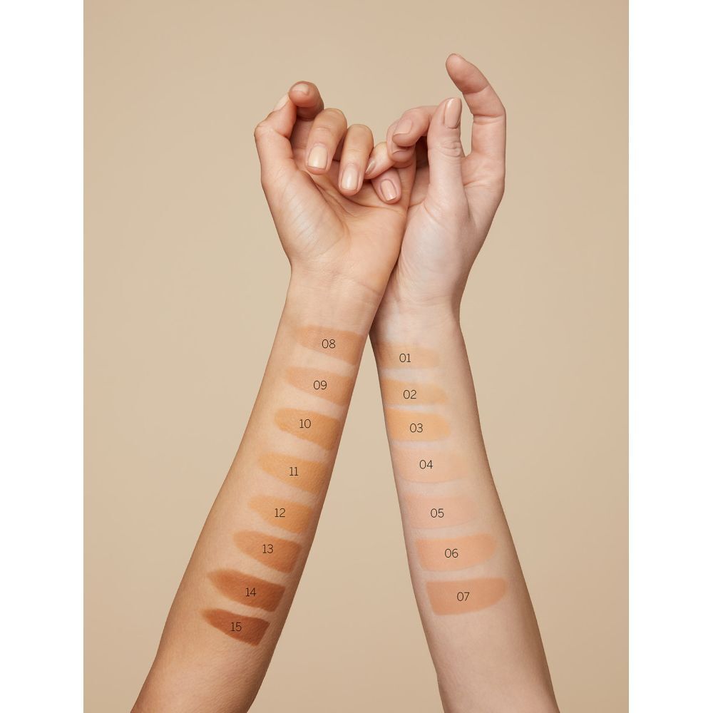 Deux bras avec des échantillons de fond de teint. Numéros de couleur 08-15 et 01-07. Fond beige.