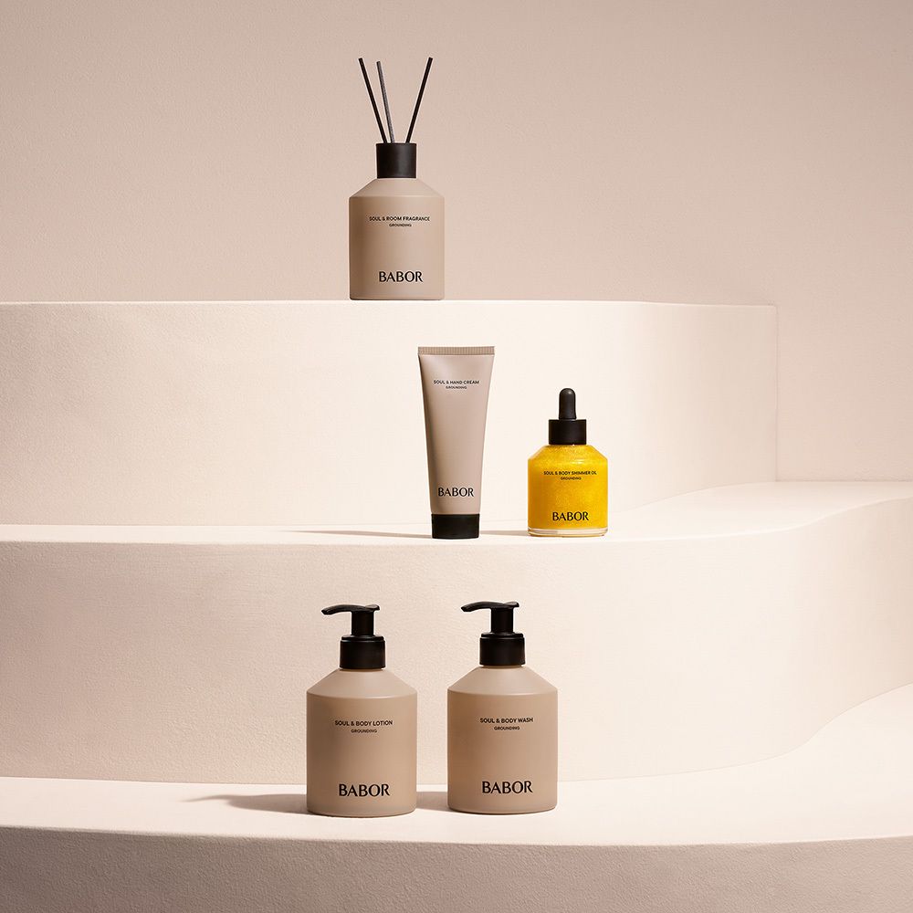 Mehrere BABOR-Produkte auf einer Treppe. Lotion-Flaschen, eine Tube, ein Ölfläschchen und ein Diffusor.