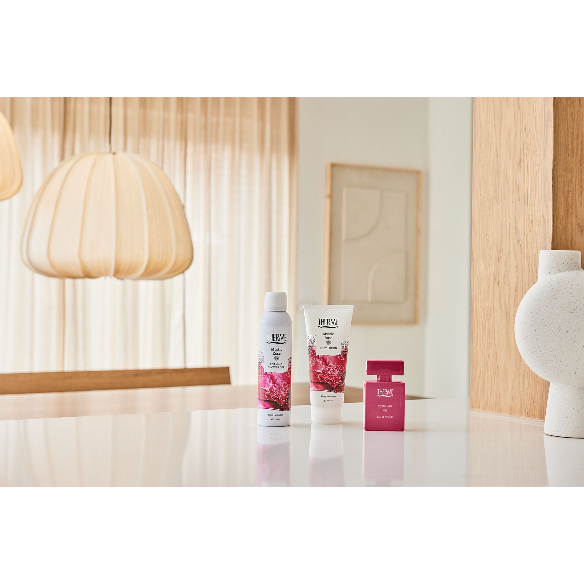 Productset op tafel. Nebel, crème, parfum. Achtergrond: lichte inrichting.