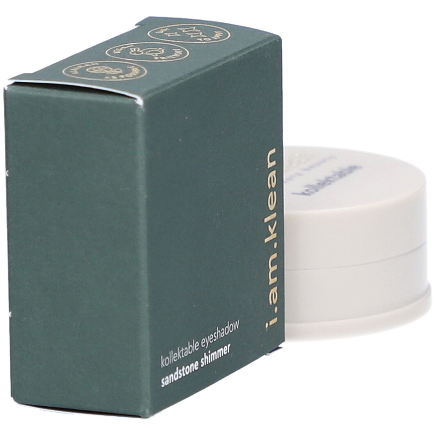 Grüne Schachtel und Dose. Auf der Schachtel steht: i.am.klean, kollektable eyeshadow, sandstone shimmer. Dose daneben.