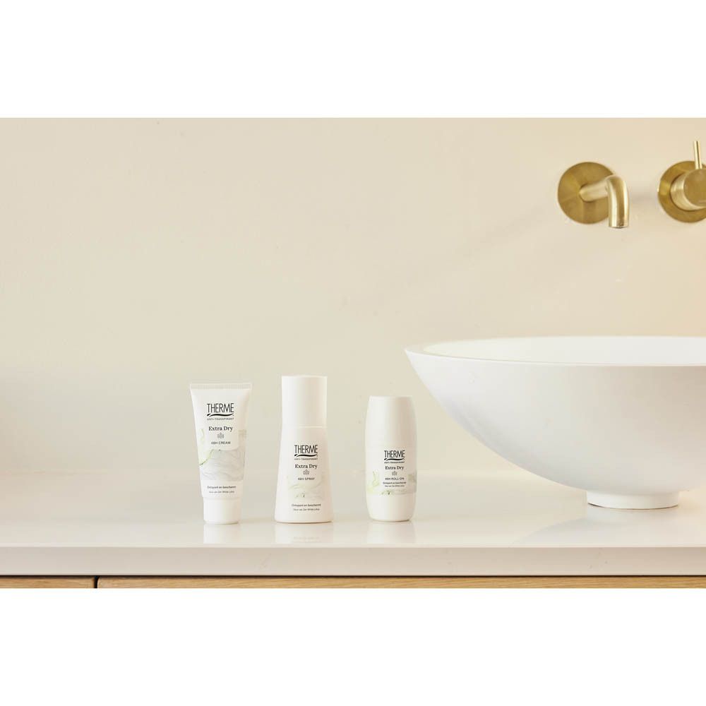 Persoon houdt Therme Anti-Transpirant Extra Dry Cream 48H vast. Product in de hand, arm in de buurt.