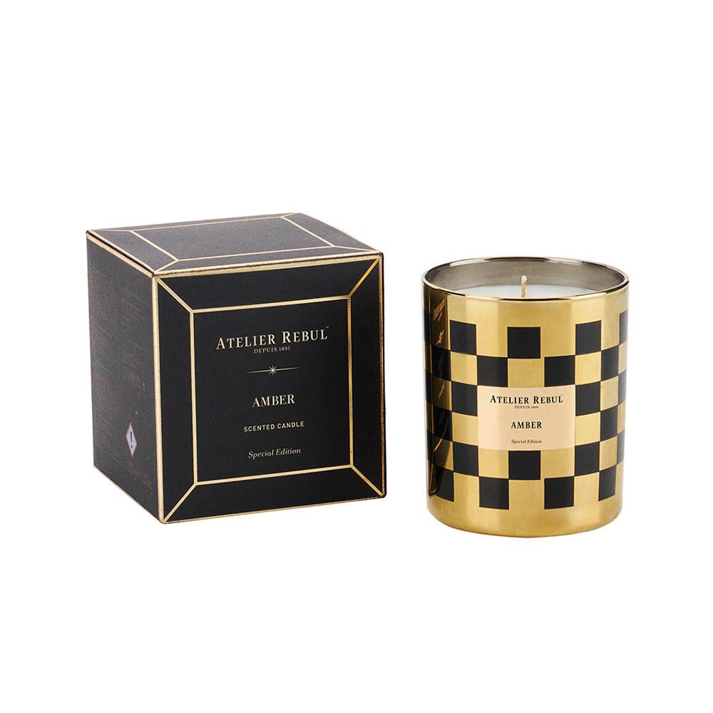 Bougie dans un verre à carreaux or et noir, à côté d'une boîte noire avec détails dorés. Inscription : "AMBER".