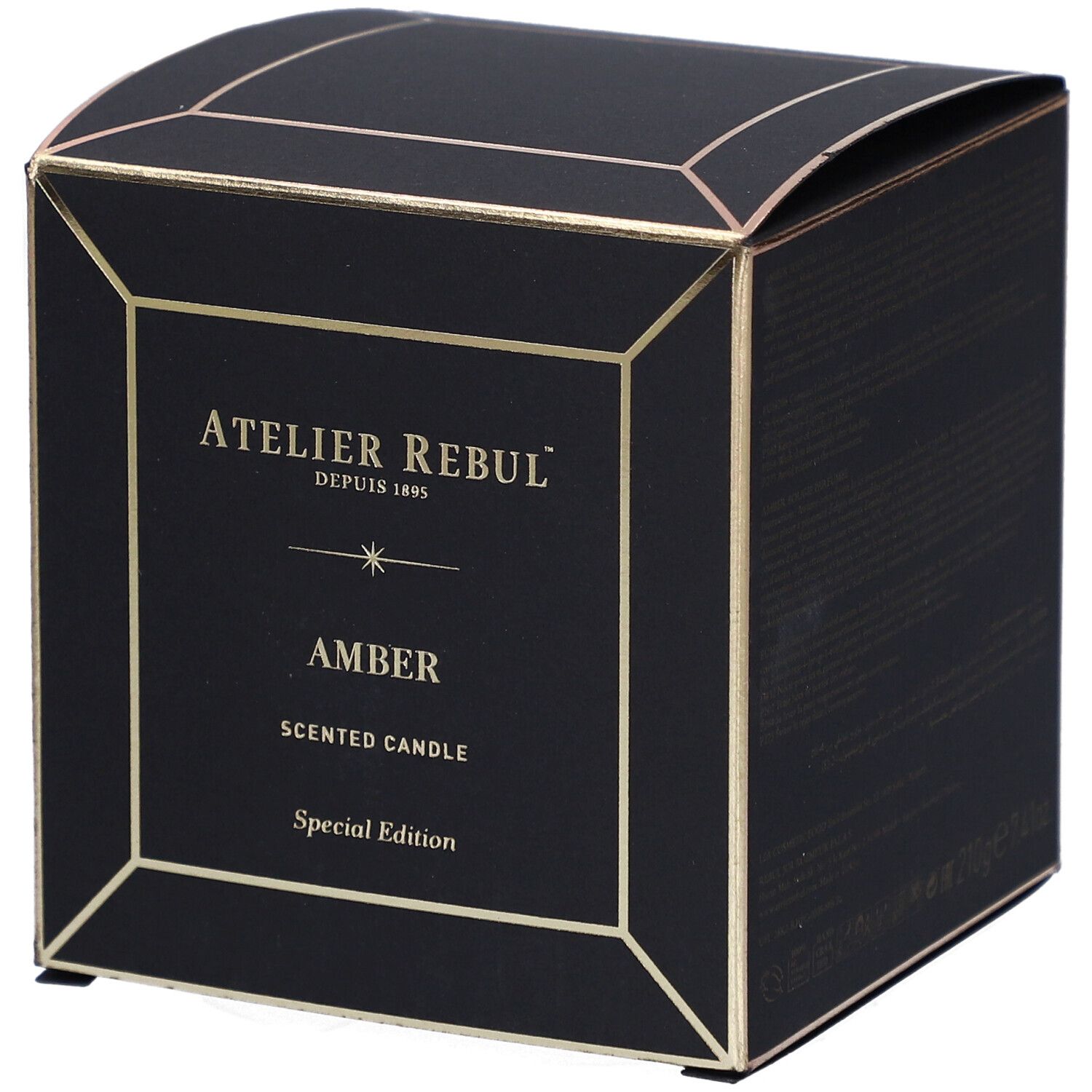 Boîte noire carrée avec détails dorés. Inscriptions : "ATELIER REBUL", "AMBER" et "SCENTED CANDLE". Édition spéciale.