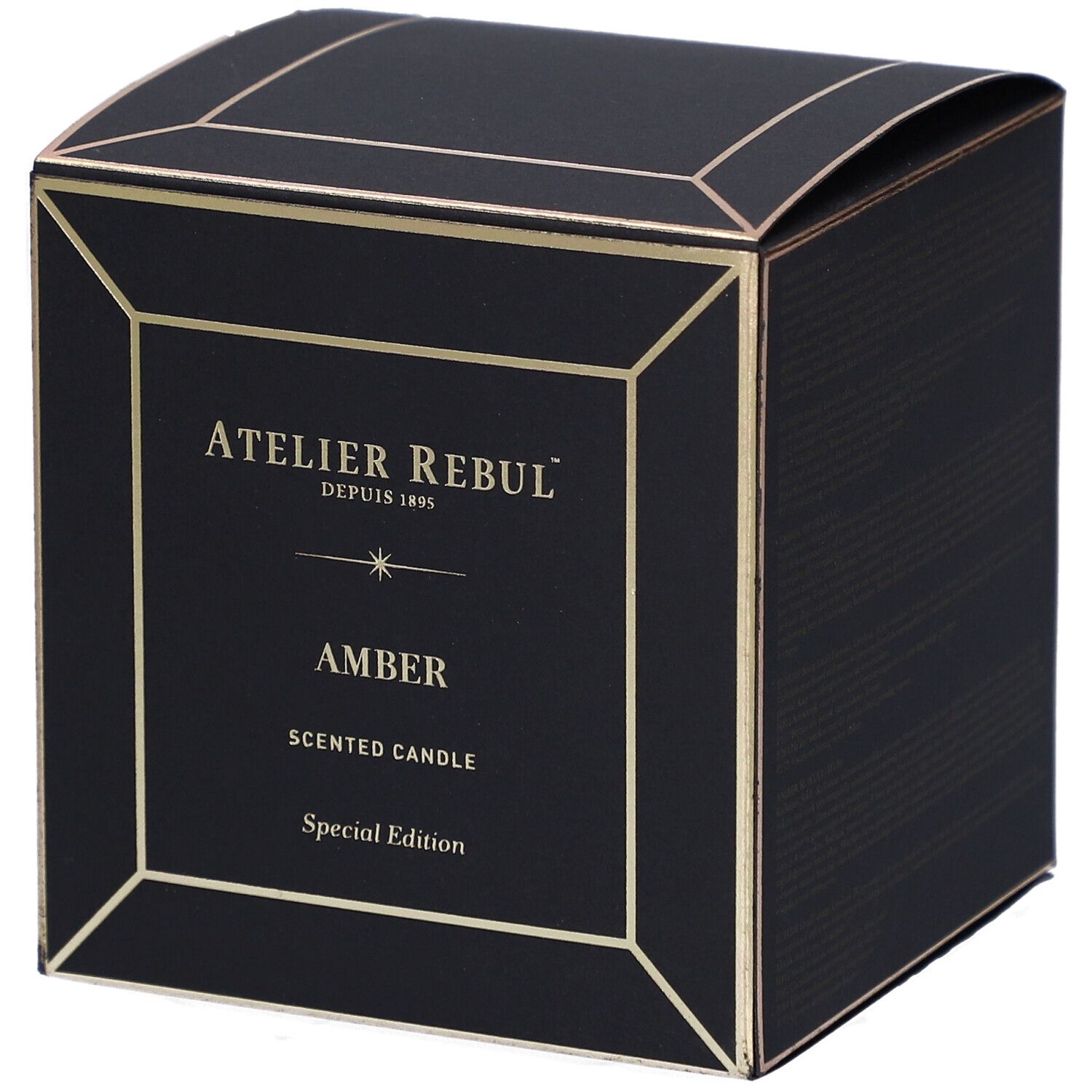 Boîte noire carrée avec détails dorés. Inscriptions : "ATELIER REBUL", "AMBER" et "SCENTED CANDLE".