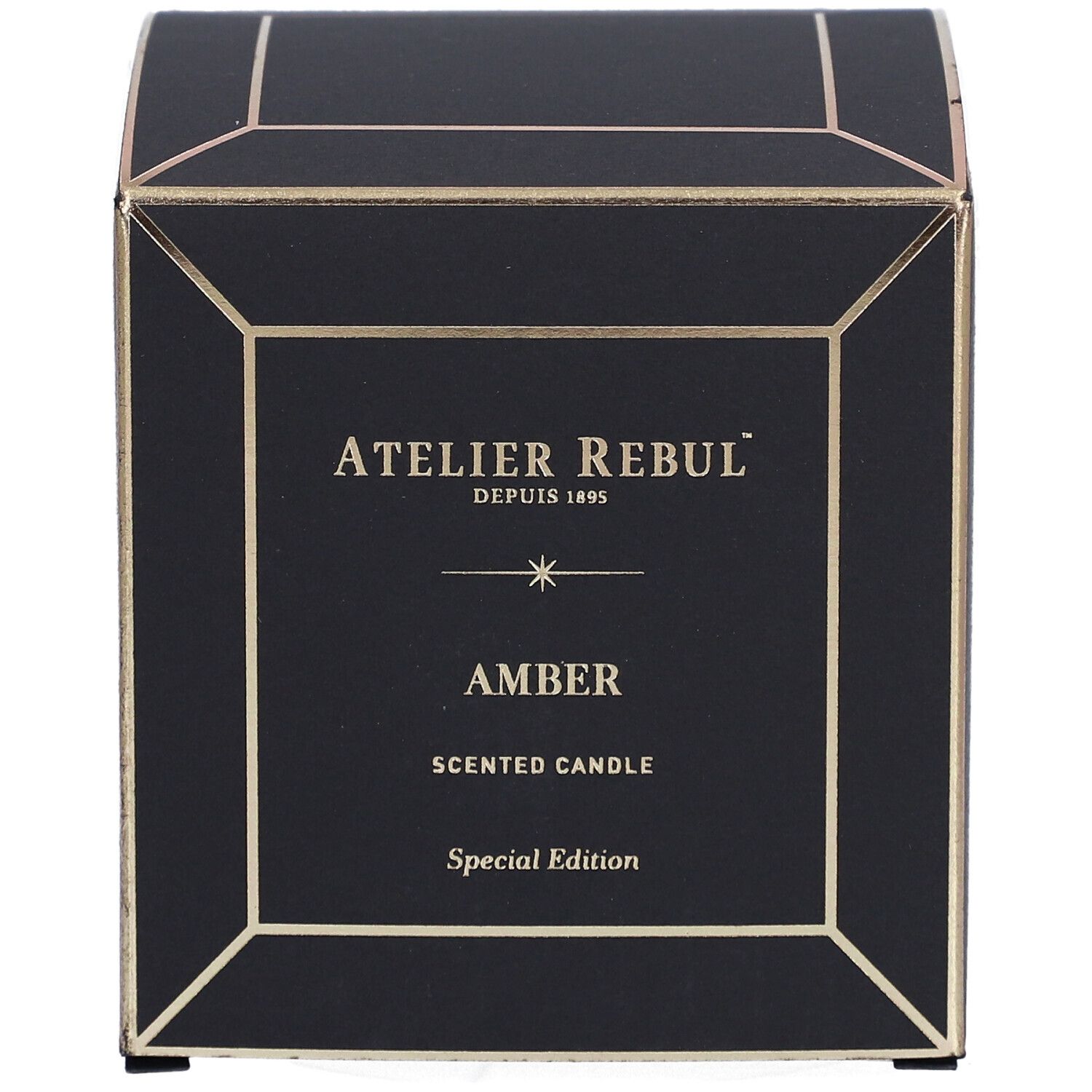 Boîte noire carrée avec détails dorés. Inscriptions : "ATELIER REBUL", "AMBER" et "SCENTED CANDLE".