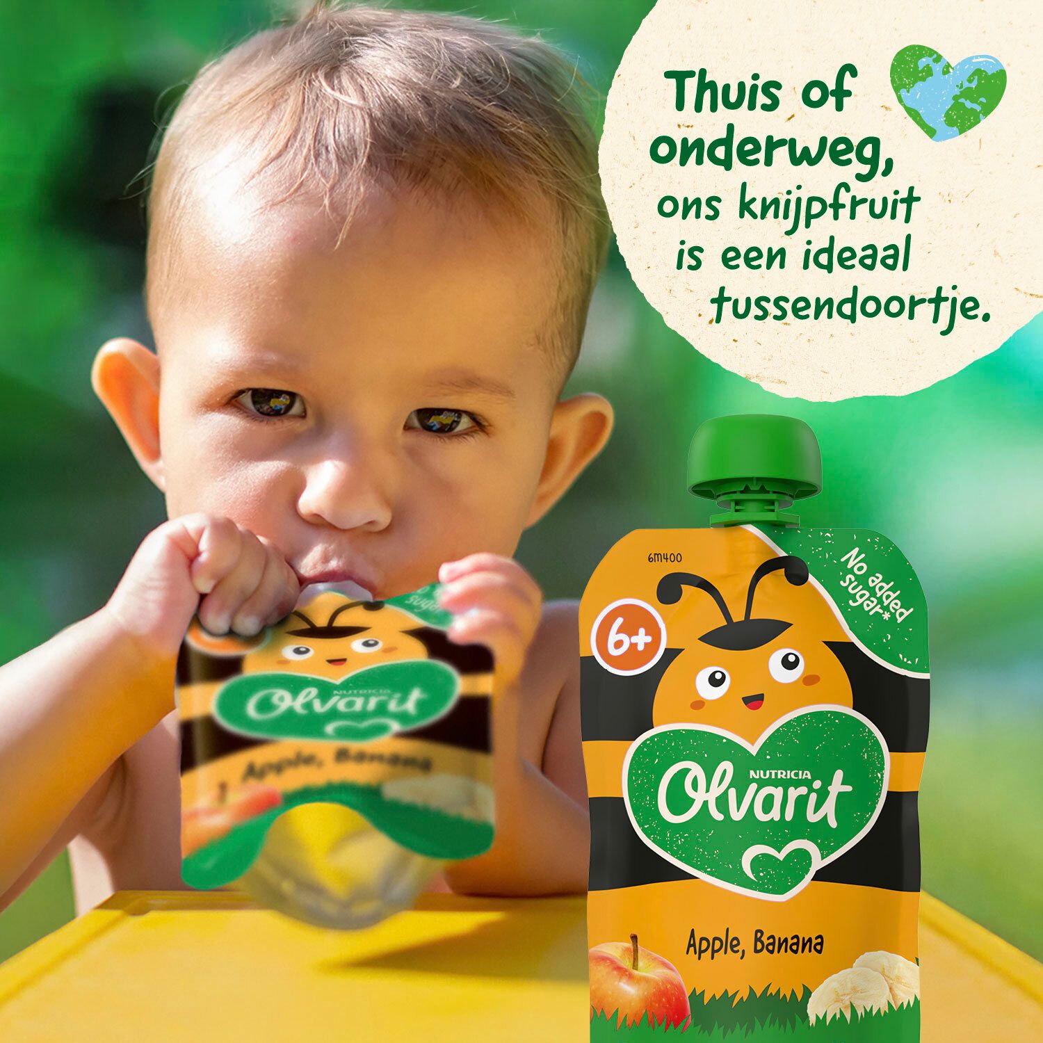 Een kind drinkt uit een knijpfruit. Merk Olvarit. Groene en witte dop. Aanbevolen voor 6+ maanden.