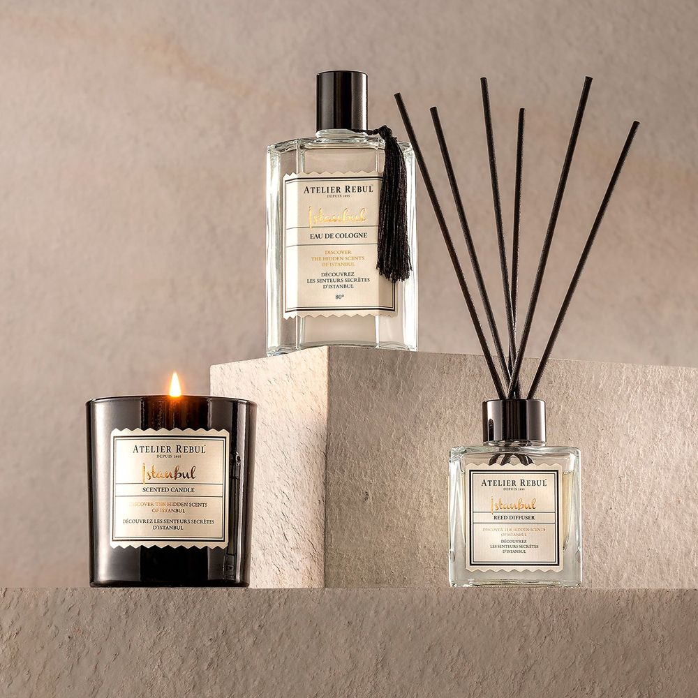 Duftkerze, Eau de Cologne und Diffusor mit Stäbchen in einem Arrangement.
