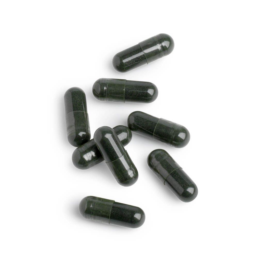 Acht groene capsules, individueel liggend op een witte achtergrond.