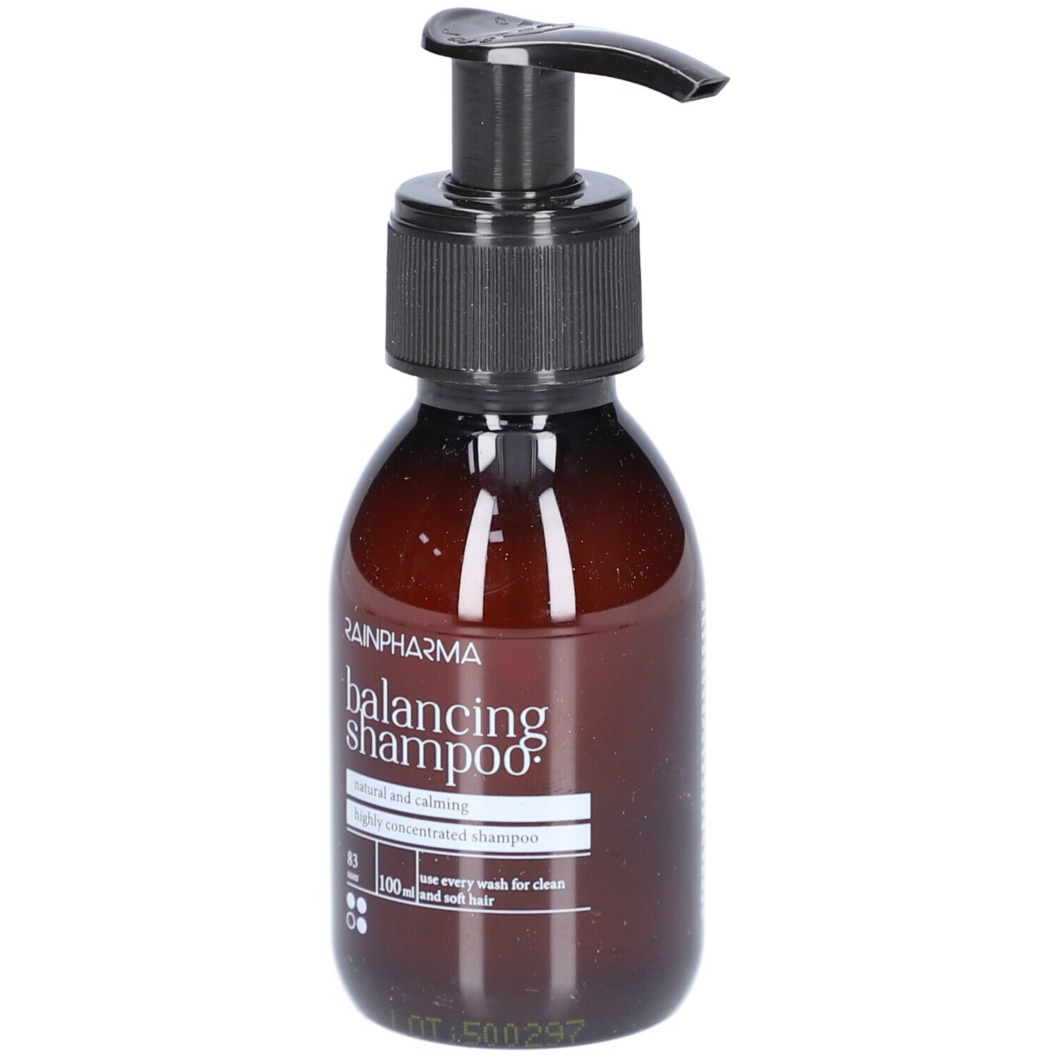 Braune Flasche mit schwarzem Pumpkopf. Aufschrift: Rainpharma balancing shampoo. Text: natural and calming, highly concentrated shampoo.