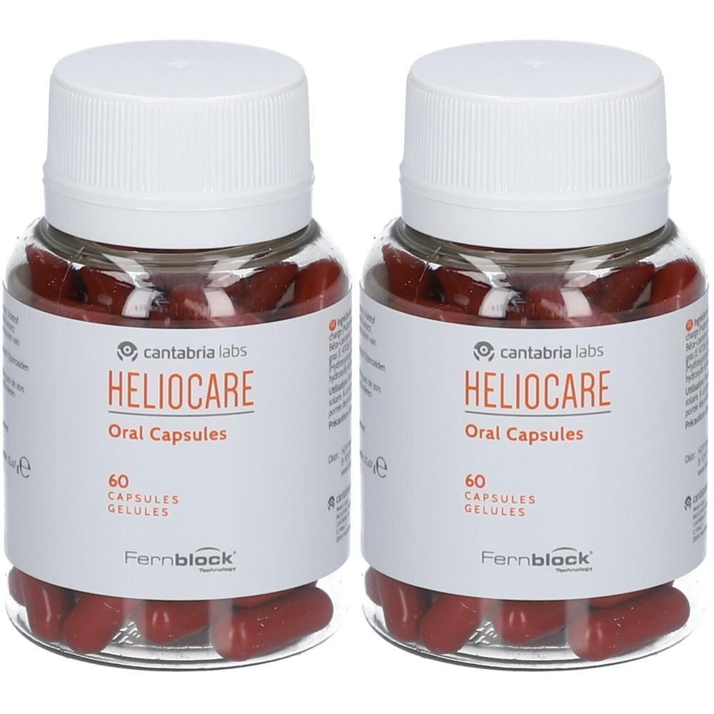 Zwei Flaschen Heliocare Oral Capsules. Klare Flaschen mit weißen Deckeln und Etiketten. Rote Kapseln sichtbar.